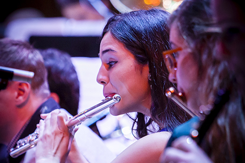 Woman plays a flute with the Jazz band